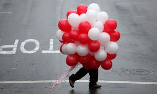 Image: A man carries a bunch of ballons as he walks down Union Street on Valentine's Day